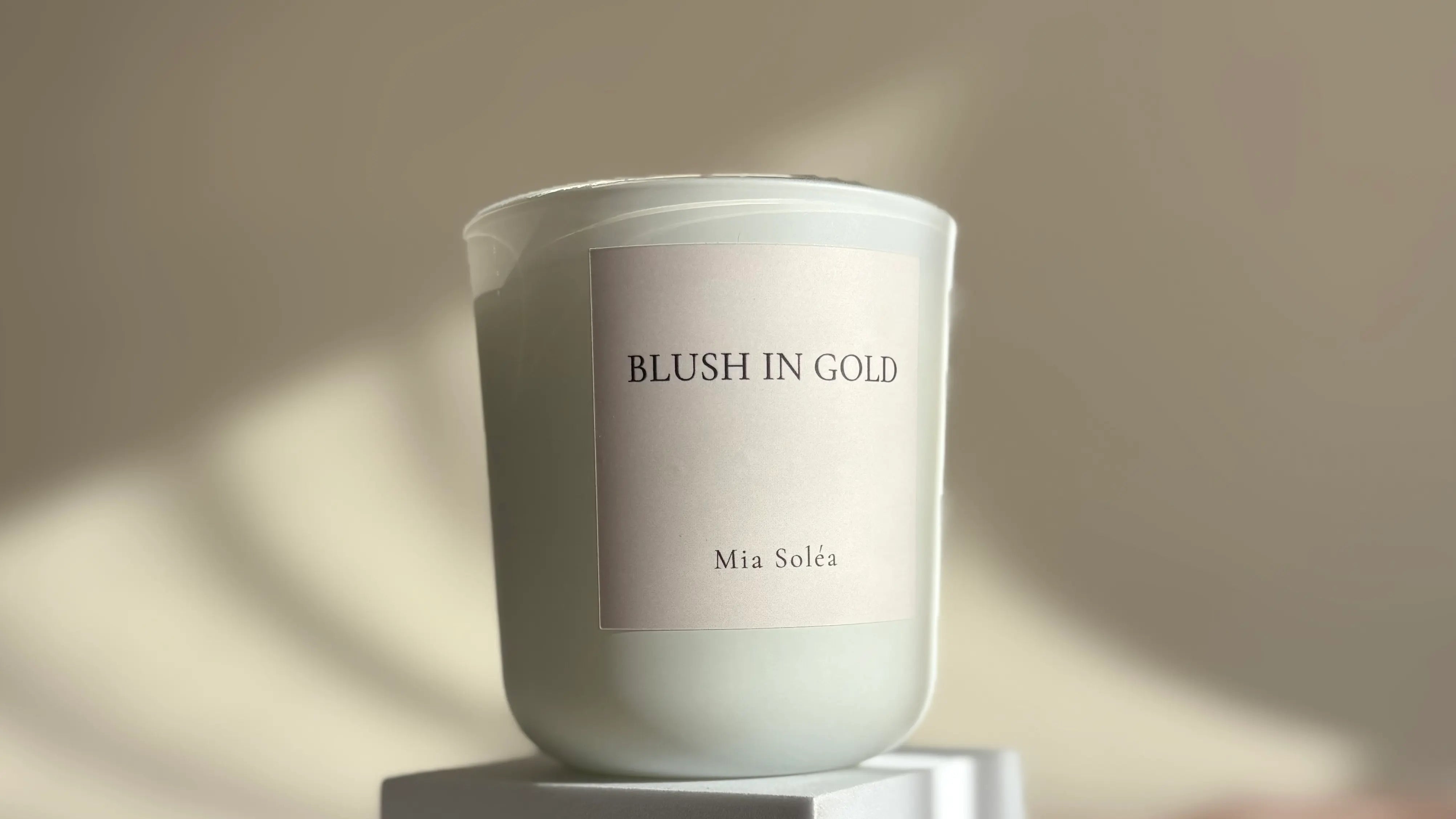 Duftkerze „Blush in Gold“ im warmen Licht mit sanften Schatten – moderner, luxuriöser Interior Moment
