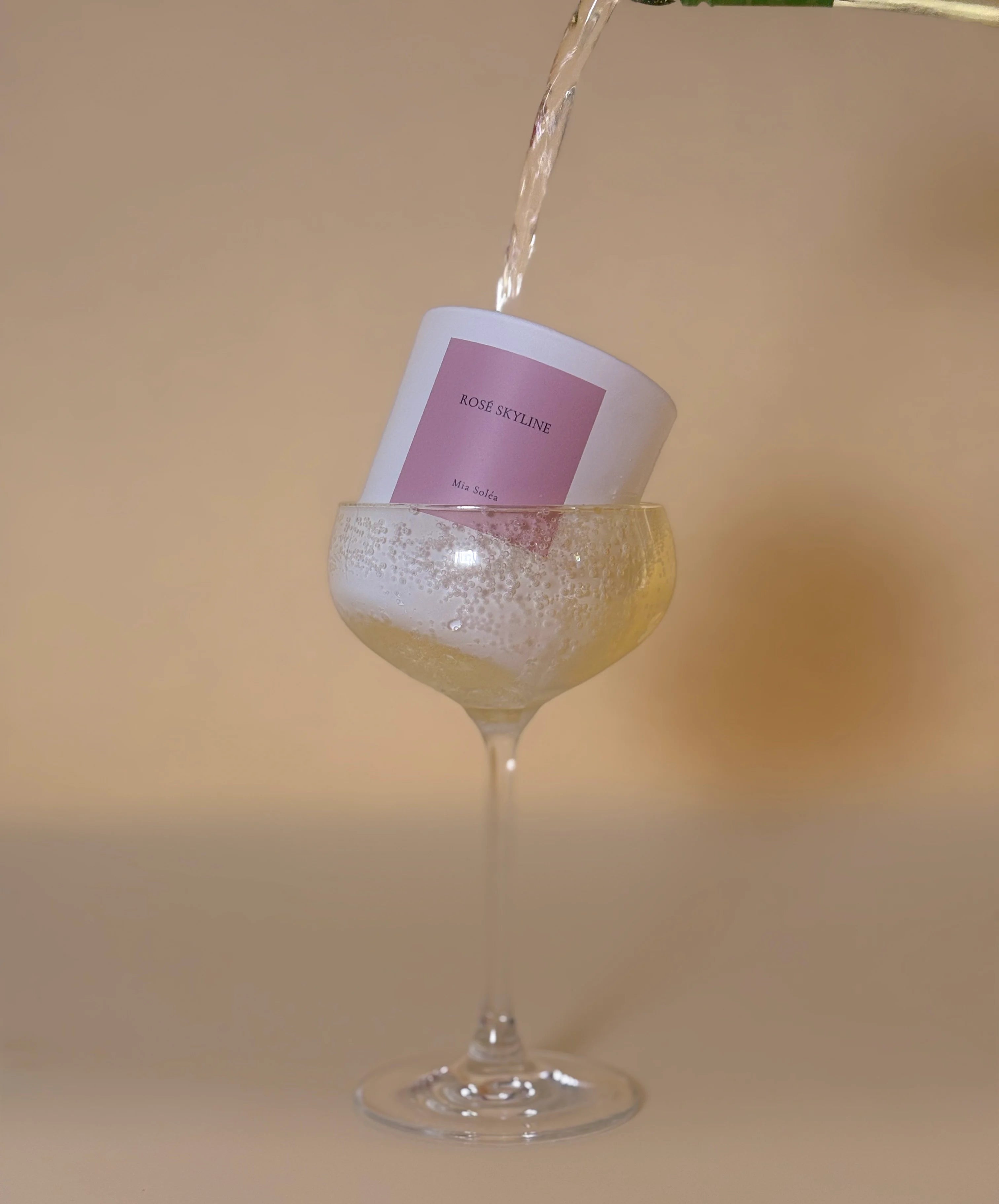 Rosé Skyline Duftkerze von Mia Soléa in einem Champagnerglas mit eingegossenem Rosé. Inspiriert von Rooftop-Abenden, Sonnenuntergängen und prickelnden Momenten.