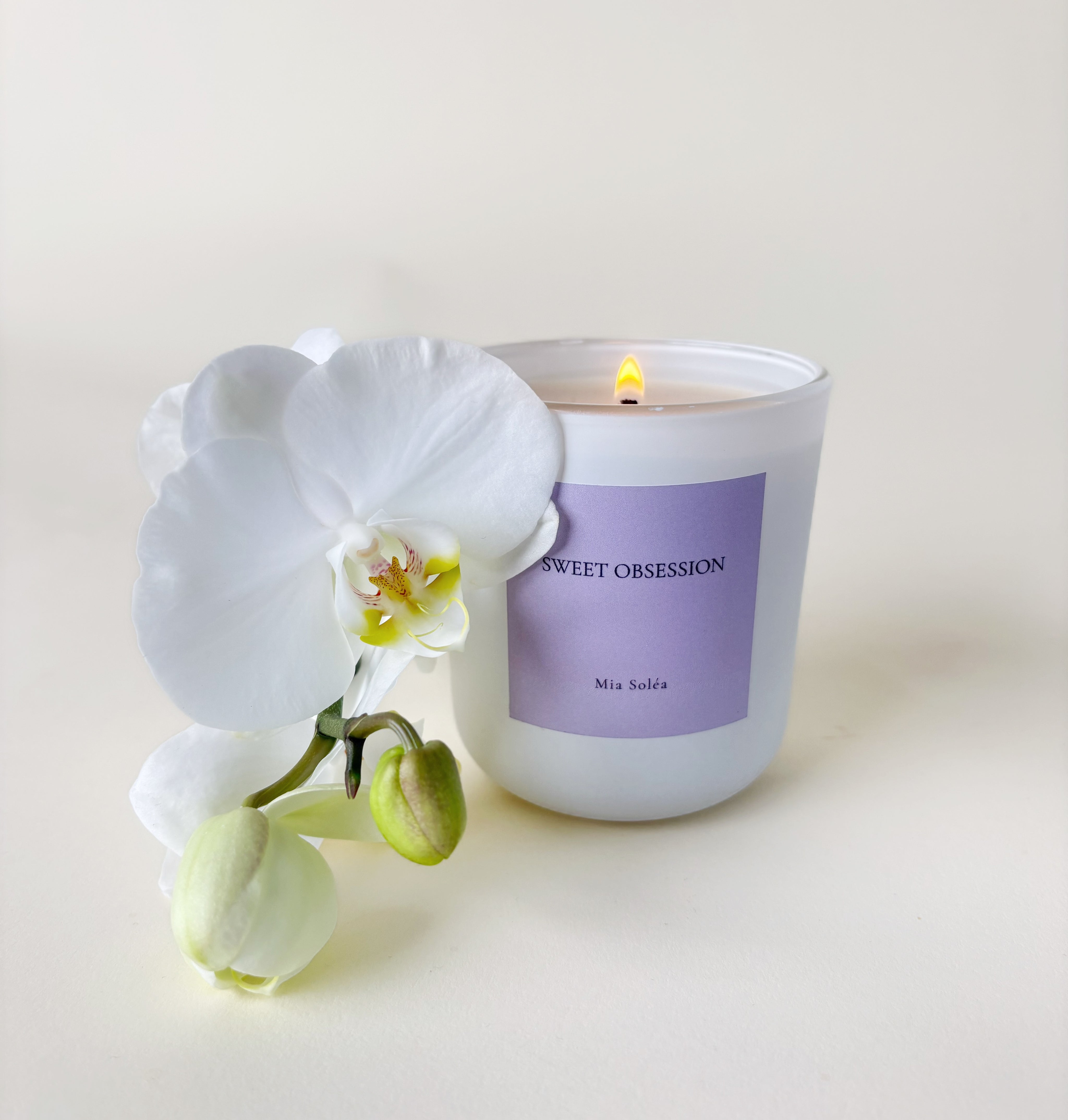 Luxuriöse Sweet Obsession Duftkerze von Mia Soléa. Sanfte Blüten, warme Vanille und Amber schaffen eine gemütliche, elegante Atmosphäre.