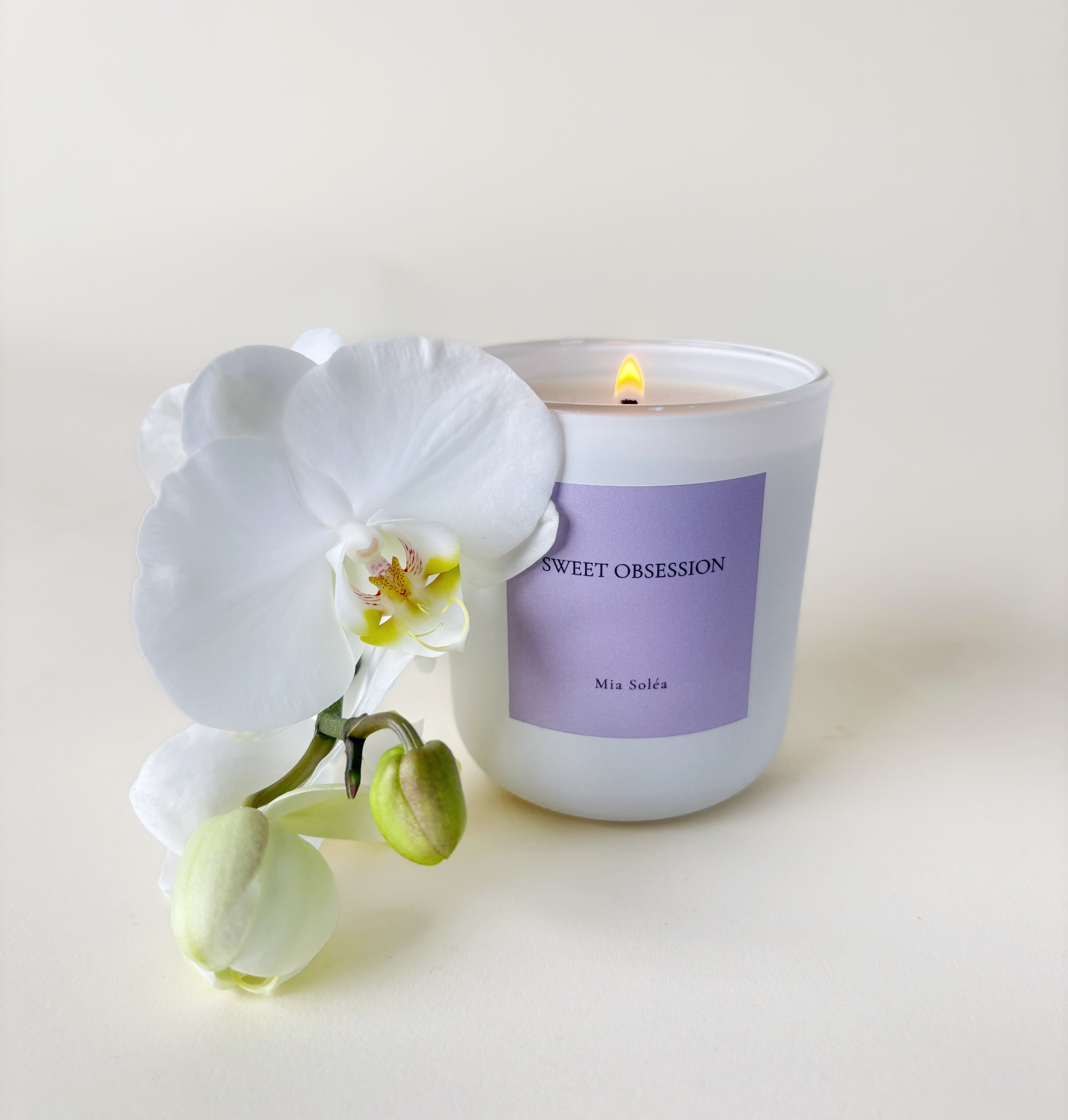 Luxuriöse Sweet Obsession Duftkerze von Mia Soléa. Sanfte Blüten, warme Vanille und Amber schaffen eine gemütliche, elegante Atmosphäre.