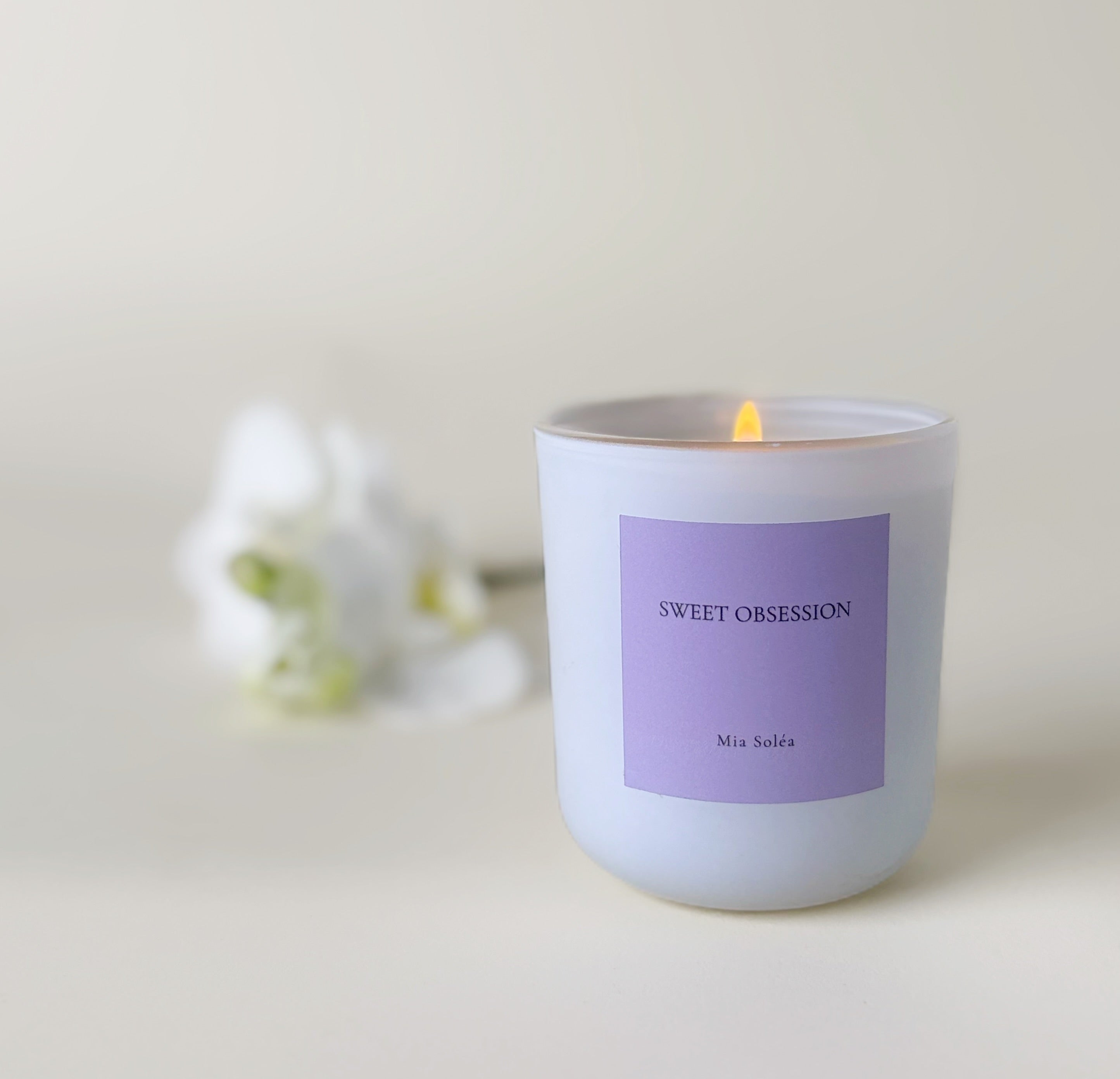 Luxuriöse Sweet Obsession Duftkerze von Mia Soléa. Sanfte Blüten, warme Vanille und Amber schaffen eine gemütliche, elegante Atmosphäre.